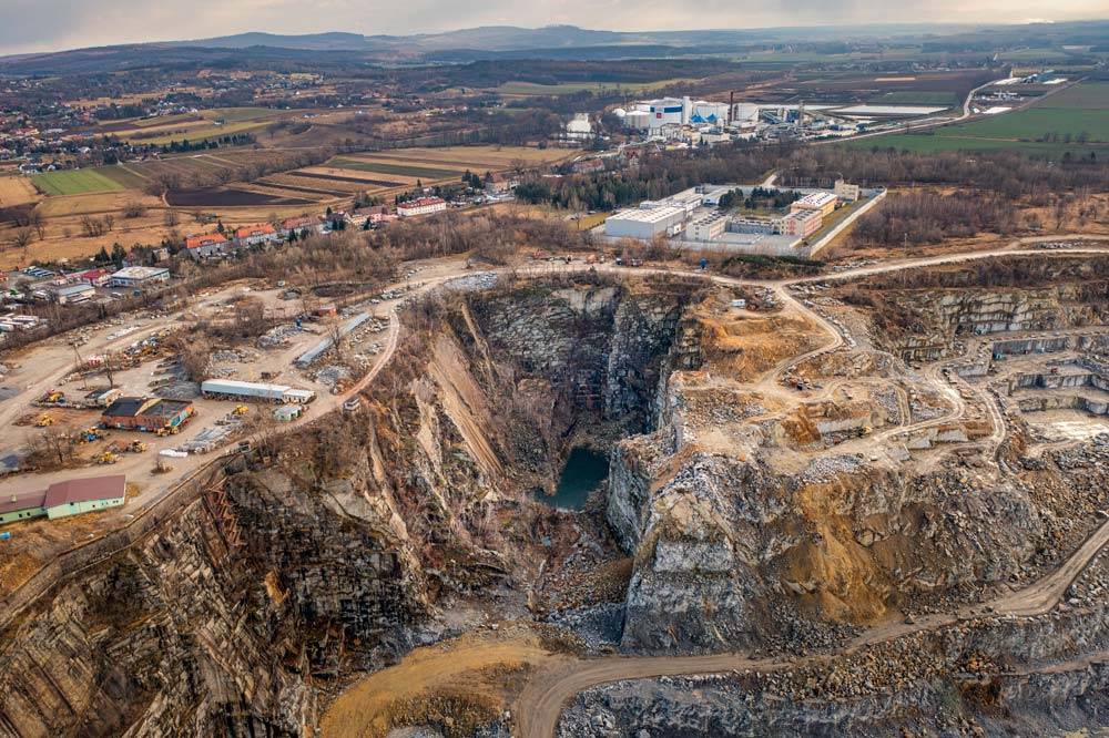 Tarasy skalne i turkusowe jezioro na dnie ogromnego kamieniołomu granitu w Strzelinie